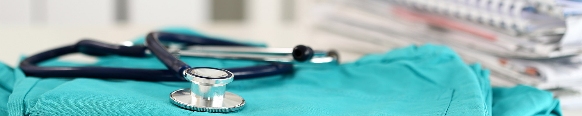 Stethoscope and scrubs sit on desk with medical reports of patient at Fair Lawn New Jersey Doctors Office